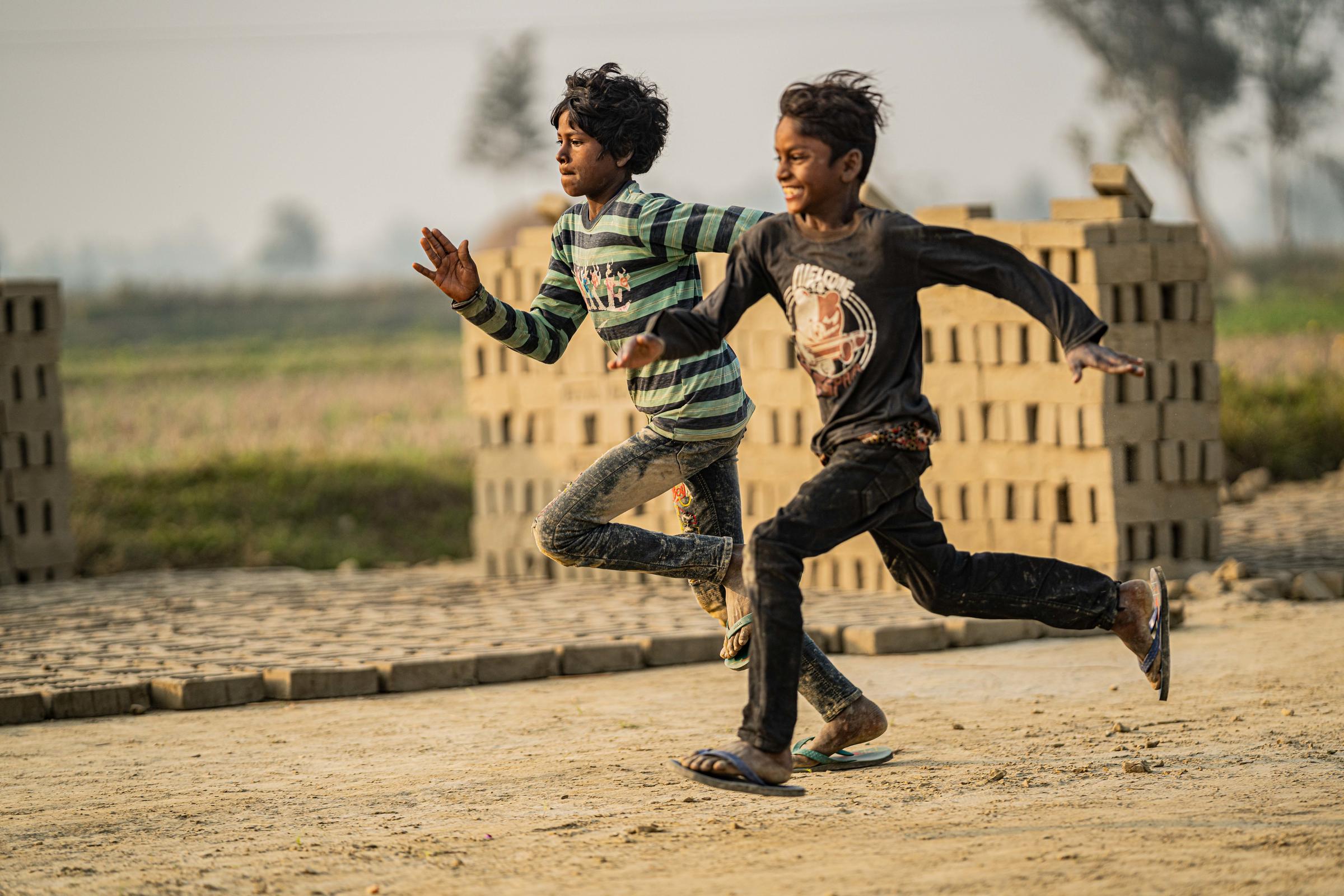 Zwei Jungen aus Nepal rennen nebeneinander um die Wette (Foto: Jakob Studnar / Kindernothilfe)